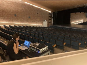 Giulia Bismara sitting in the back of a theatre with headphones